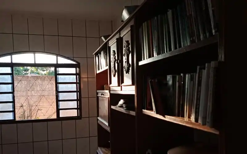 Estante de madeira com livros cristãos na biblioteca do campus residencial