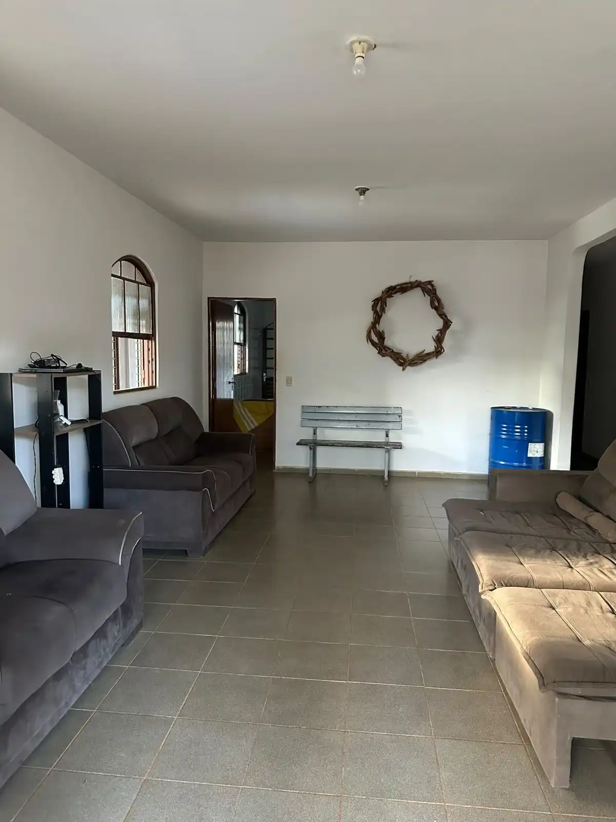 Sala de convivência tranquila com sofás e uma coroa de espinhos decorativa na parede